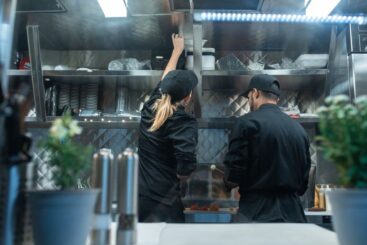 Een moderne horecakeuken met diverse professionele keukenapparatuur zoals koeltoonbanken en ovens.