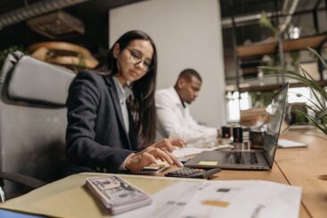 Een ondernemer die zijn financiën beheert met een laptop en notitieboekje, gericht op transparantie in kosten.